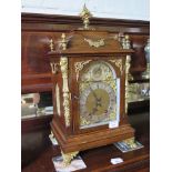 A late Victorian walnut and ormolu bracket clock, the flare finial over a caddy top above figural