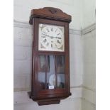 A 1930s wall clock, with silvered square dial and glazed door, the three train movement striking