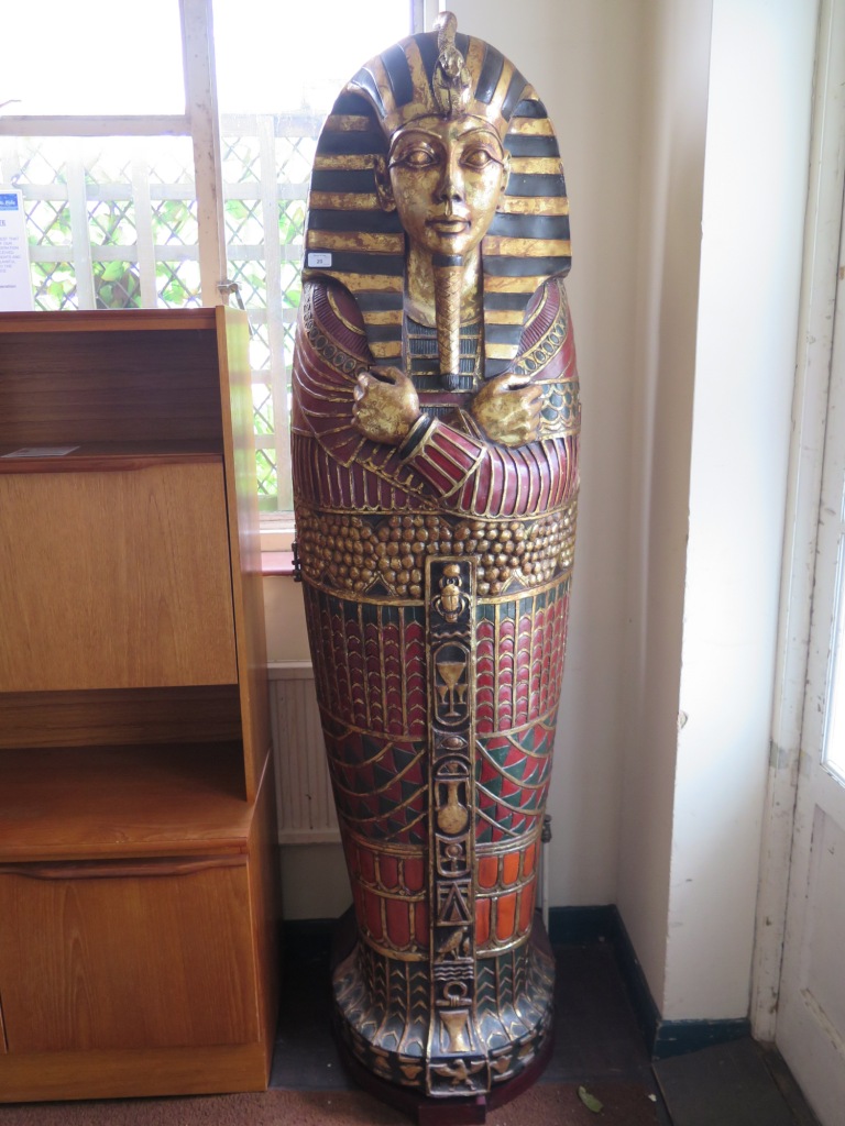 An Egyptian style hinged bookcase in the form of Tutankhamun's sarcophagus, 189cm high