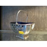 A swing handle silver sugar basket with blue liner, the basket with pierced decoration, Birmingham