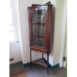 An Edwardian mahogany and satinwood crossbanded corner cabinet, with astragal glazed door on