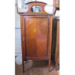 An Edwardian mahogany and satinwood crossbanded music cabinet, the mirrored back over a bowfront