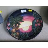 A Moorcroft limited edition Millenium plate depicting a sunset and figure playing a seashell, 1295