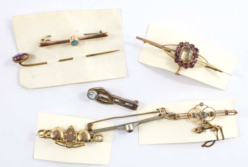 A collection of seven gem set brooches