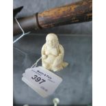 An early 20th century ivory okimono of a Buddhist figure holding a ball, possibly Ho Tai, 4.5cm