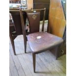 A pair of 1950s teak dining chairs, with leather back and seat impressed with the coat of arms for