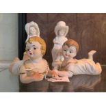 A pair of Gebruder Heubach bisque piano babies 14cm long, and a pair of German porcelain figures (