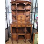 A mid Victorian walnut side cabinet, the raised back with lion masks and fret carving over three