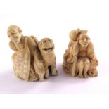 Two Meiji period ivory Netsuke, one depicting a man sitting with a tiger, the other of a man sitting