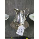 *A small silver plated cream jug and stand