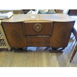 A 1930's walnut sideboard, with fall front drinks cabinet and two drawers flanked by bowed doors,