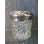 A silver topped vanity glass jar