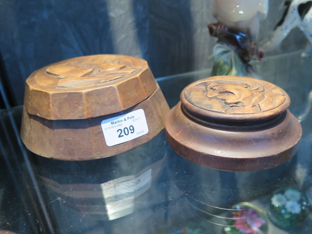 A pair of Black Forest carved wood table snuff boxes, the lids depicting profile faces 14cm diameter