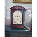 A Regency rosewood and brass inlaid bracket clock, the arched case with grape and vine ring handles,