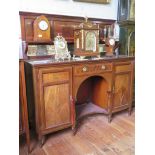 An Edwardian mahogany and satinwood crossbanded sideboard, the raised back with mirror panel and