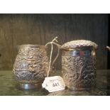 A silver colour metal Indian cream jug decorated in relief with flora and fauna and a box with lid