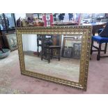 A giltwood rectangular wall mirror, with bevelled plate and foliate frame, 81cm x 111cm