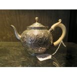 A Victorian silver bachelor's teapot with ivory handle, the teapot decorated in relief with flower