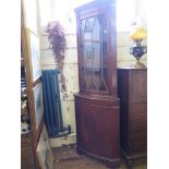 A reproduction mahogany corner cabinet, with glazed and oval veneered doors, 65cm x 101cm, and a