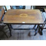 A mid Victorian walnut window table, the rounded rectangular top with inlaid oval on turned supports