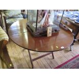 An Edwardian mahogany campaign table, the folding circular top on a folding trestle base, 99cm