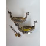 A pair of Continental salts in the form of Viking long ships, with spoons