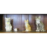 Two Winstanley pottery cat figures, seated, with glass eyes, 29cm and 23cm high, and two other cat