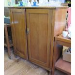 An oak two door panelled cupboard on square baluster legs, with fitted interior, 93cm wide, 43cm