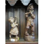 A German carved sculptured model of a young girl dancing, 24cm high and a boy playing a flute