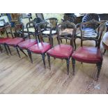 A set of six Victorian dining chairs, the hooped backs with carved mid and top rails above stuff-