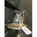 *A small silver plated cream jug and stand