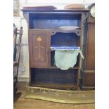 An Art Nouveau style oak bookcase, the open shelves with a single cupboard door with inlaid floral