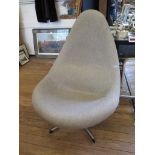 A 1970's teardrop shaped lounge chair with taupe upholstery on a chromed base, influenced by Arne