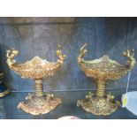 A pair of Louis XIV style gilt metal tazzas, the boat form dishes with masks, figural handles and