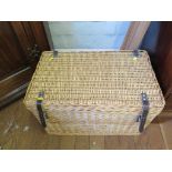 A whicker picnic basket with fitted interior including champagne flutes, plates and cutlery for