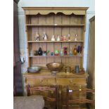 A pine dresser and rack, the rack with three stepped shelves, above two frieze drawers and two