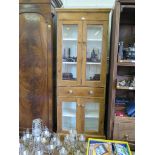 A pine glazed cabinet, with two pairs of doors and central drawer, 75cm wide, 189cm high
