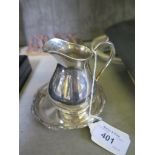 *A small silver plated cream jug and stand