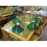 A six light brass snooker table ceiling light, with green glass shades, 110cm long