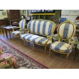 A Louis XV style carved giltwood drawing room suite of two armchairs and a settee, with C-scroll top