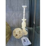 An early 20th century ivory puzzle ball on a figural stand