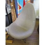 A 1970's teardrop shaped lounge chair with taupe upholstery on a chromed base, influenced by Arne