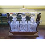 A mahogany and silver plated three decanter tantalus set, 39cm wide