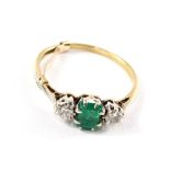 A three stone diamond and emerald ring