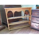 A pine shelf unit, the arcaded top with turned supports over three shelves