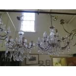 A twelve light crystal electrolier, the lights on two tiers with scroll arms and pendant swags on