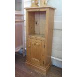 A small pine cabinet, with recessed opening over a cupboard door and plinth base, 43cm wide, 104cm