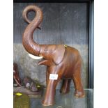 A carved hardwood elephant, the trunk held aloft, 39cm high