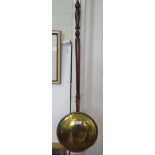 A brass warming pan with foliate decoration 103cm high