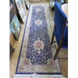 A Cashmere runner, the blue ground with three ivory medallions and all over scroll design within